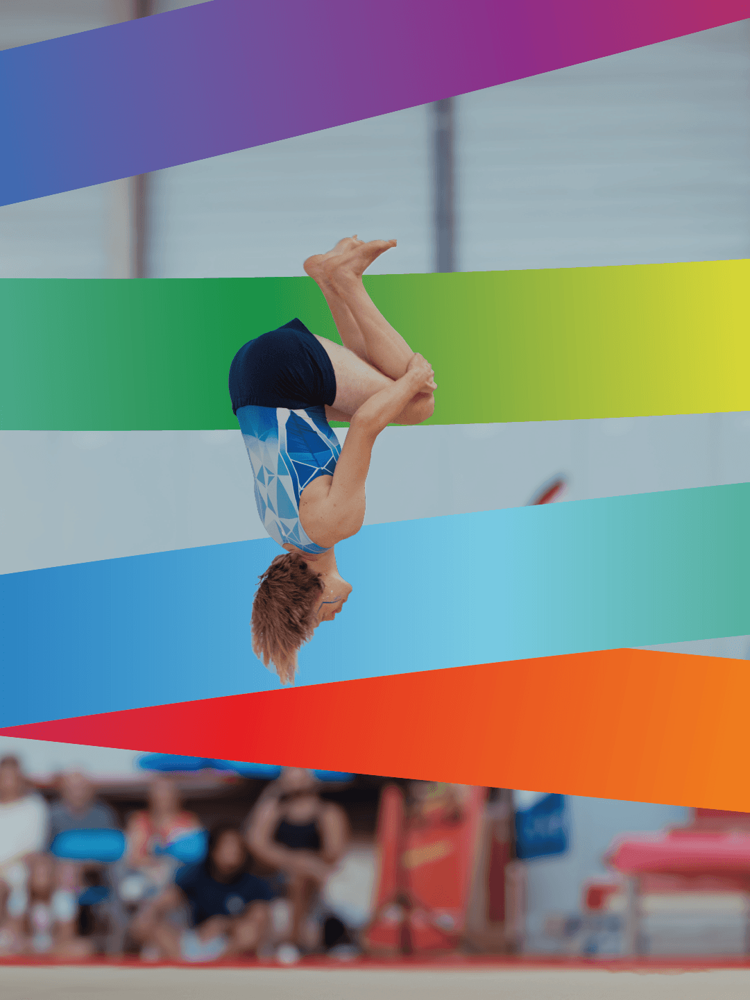 Turnster voert een indrukwekkende salto uit tijdens een turnwedstrijd, met kleurrijke achtergrondstrepen.